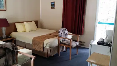 a hotel room with a bed and a chair at AppleTree Inn in Radium Hot Springs