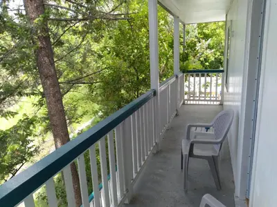 a porch with two chairs and trees on it at AppleTree Inn in Radium Hot Springs