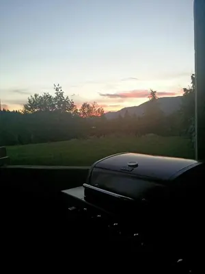 a laptop sitting on a table with the sunset in the background at Cowichan Calling in Lake Cowichan