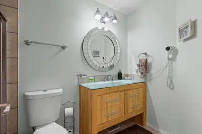 a bathroom with a toilet and a sink and a mirror at 4 Bedroom 4 Bathroom 2 Kitchen House in Bridlewood in Calgary
