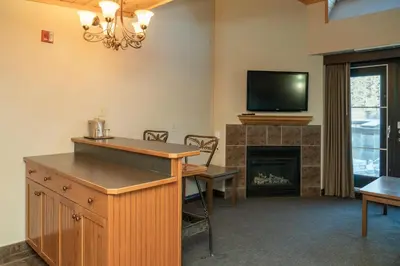 a living room with a fireplace and a flat screen tv at The Rundlestone Lodge in Banff