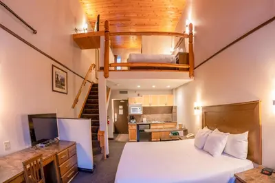 a bedroom with a bed and a loft at The Rundlestone Lodge in Banff