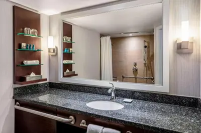 a bathroom with a sink and a large mirror at Delta Hotels by Marriott Burnaby Conference Centre in Burnaby