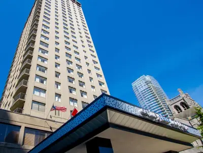 a tall white building with a flag in front of it at Century Plaza Hotel in Vancouver