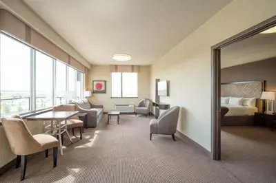 a hotel room with a bed and a table and chairs at Acclaim Hotel by CLIQUE in Calgary