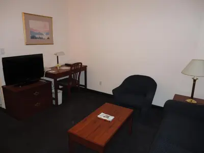 a living room with a couch and a tv and a table at Rosedale on Robson Suite Hotel in Vancouver