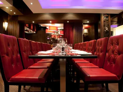 a dining room with red chairs and a table with wine glasses at Fantasyland Hotel in Edmonton
