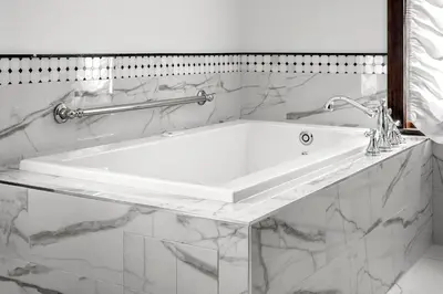 a white bath tub in a bathroom with marble walls at Abigail's Hotel in Victoria
