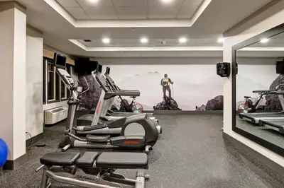 a gym with cardio machines and a superhero mural at Canalta Lodge in Banff