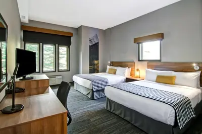 a hotel room with two beds and a flat screen tv at Canalta Lodge in Banff