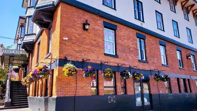 a brick building with flower boxes on the side of it at James Bay Inn Hotel, Suites & Cottage in Victoria