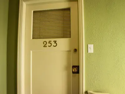 a white door with a window with the number at James Bay Inn Hotel, Suites & Cottage in Victoria
