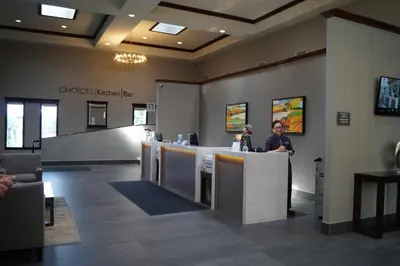 a woman standing at a counter in a waiting room at Radisson Hotel & Conference Centre Edmonton in Edmonton
