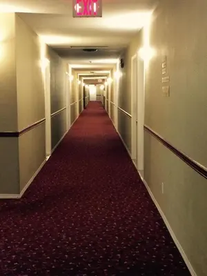 a long corridor with a red carpet in a building at Super 8 by Wyndham West Kelowna BC in West Kelowna