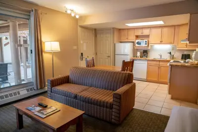 a living room with a couch and a kitchen at Banff Rocky Mountain Resort in Banff