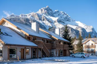 a building with a snow covered mountain in the background at Banff Rocky Mountain Resort in Banff