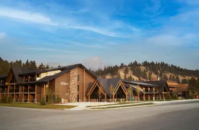 a large building with a mountain in the background at Forest Park Hotel in Jasper