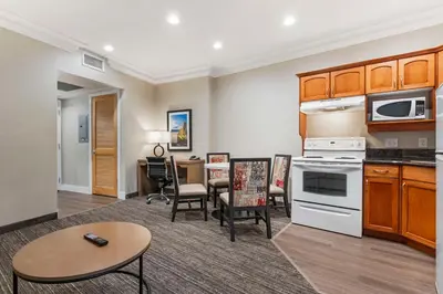 a living room with a kitchen and a dining room at Best Western Plus Kelowna Hotel & Suites in Kelowna