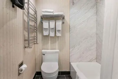a bathroom with a toilet and a sink and towels at Best Western Plus Kelowna Hotel & Suites in Kelowna