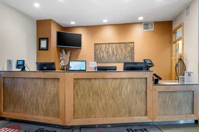 a lobby with a reception desk with two laptops at Best Western Plus Kelowna Hotel & Suites in Kelowna