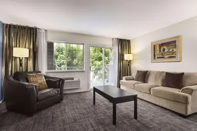 a living room with a couch and a chair and a table at Days Inn by Wyndham Kelowna in Kelowna