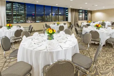 a banquet room with white tables and chairs with flowers at Holiday Inn Vancouver-Centre Broadway by IHG in Vancouver