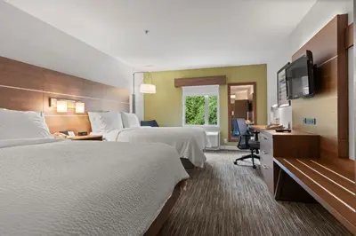 a hotel room with two beds and a flat screen tv at Holiday Inn Express and Suites Surrey by IHG in Surrey