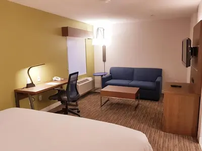a hotel room with a bed and a desk and a couch at Holiday Inn Express and Suites Surrey by IHG in Surrey