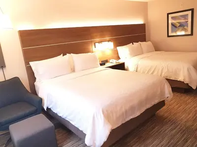 a hotel room with two beds and a chair at Holiday Inn Express and Suites Surrey by IHG in Surrey