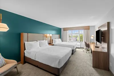 a hotel room with two beds and a desk and a television at Holiday Inn Hotel & Suites Surrey East - Cloverdale by IHG in Surrey