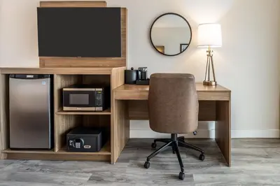 a desk with a television and a chair in a room at Atrium Hotel Vancouver in Vancouver