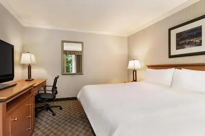 a hotel room with a bed and a desk and a computer at Holiday Inn & Suites North Vancouver by IHG in North Vancouver