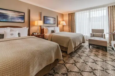 a hotel room with two beds and a chair at The Magnolia Hotel & Spa in Victoria