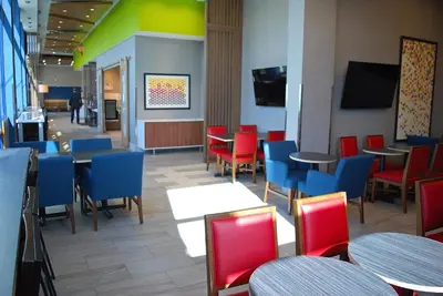 a restaurant with tables and chairs and a tv at Holiday Inn Express Vancouver Airport-Richmond by IHG in Richmond