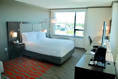 a hotel room with a bed and a desk with a computer at Holiday Inn Vancouver Airport Richmond by IHG in Richmond