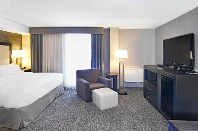 a hotel room with a bed and a television at Holiday Inn Express and Suites Calgary by IHG in Calgary