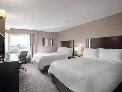 a hotel room with two beds and a window at Holiday Inn Calgary Airport by IHG in Calgary