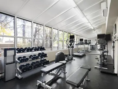 a gym with a lot of equipment and windows at Holiday Inn Calgary Airport by IHG in Calgary