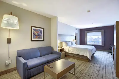 a hotel room with a bed and a couch at Holiday Inn Express Airport Calgary by IHG in Calgary