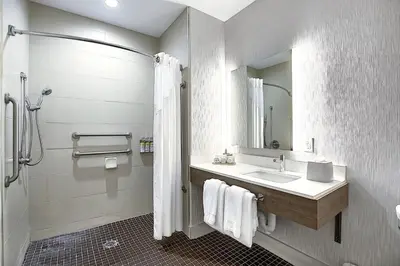 a bathroom with a sink and a shower with a mirror at Holiday Inn Express Airport Calgary by IHG in Calgary