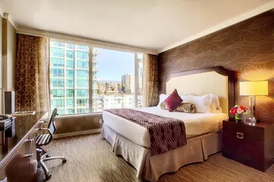 a hotel room with a bed and a large window at Pinnacle Hotel at the Pier in North Vancouver