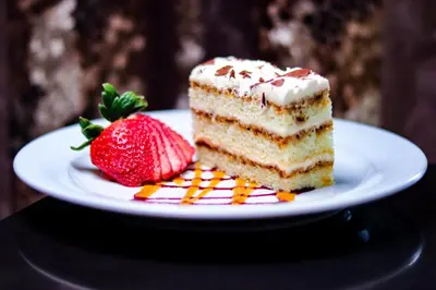 a piece of cake and a strawberry on a plate at Pinnacle Hotel at the Pier in North Vancouver