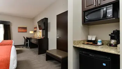a hotel room with a bed and a kitchen with a microwave at Holiday Inn Express Hotel & Suites - Edmonton International Airport by IHG in Nisku
