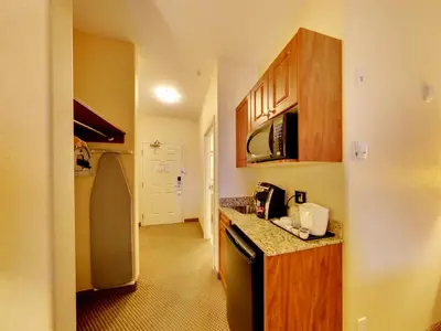 a small kitchen with a counter and a refrigerator at Holiday Inn Express Hotel & Suites - Edmonton International Airport by IHG in Nisku
