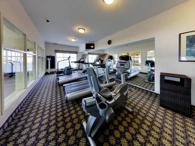 a gym with treadmills and ellipticals in a building at Holiday Inn Express Hotel & Suites - Edmonton International Airport by IHG in Nisku