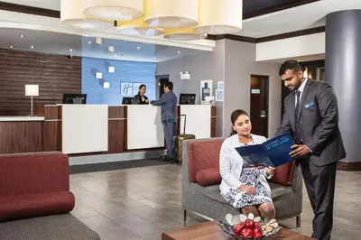 a man and a woman sitting in a chair in a lobby at Holiday Inn Express Edmonton Downtown by IHG in Edmonton