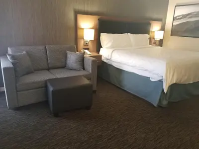a hotel room with a bed and a chair at Holiday Inn Express Edmonton Downtown by IHG in Edmonton