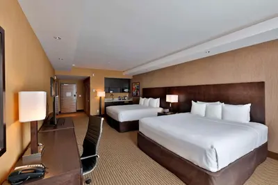 a hotel room with two beds and a desk at Edmonton Hotel & Convention Center Edmonton in Edmonton