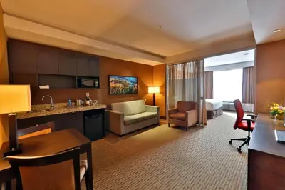 a hotel room with a kitchen and a living room at Edmonton Hotel & Convention Center Edmonton in Edmonton