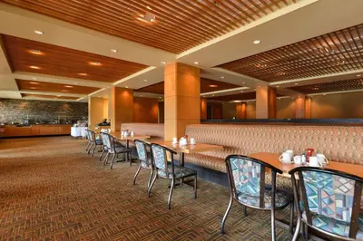 a dining area with tables and chairs in a restaurant at Edmonton Hotel & Convention Center Edmonton in Edmonton